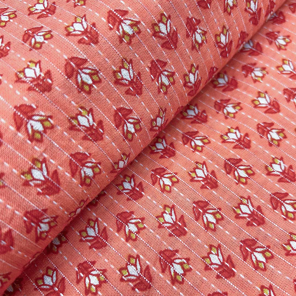 Soft pinkish-orange cotton fabric adorned with small floral Kantha stitching, offering a touch of artisanal beauty at Fabrics @StudioLCX.