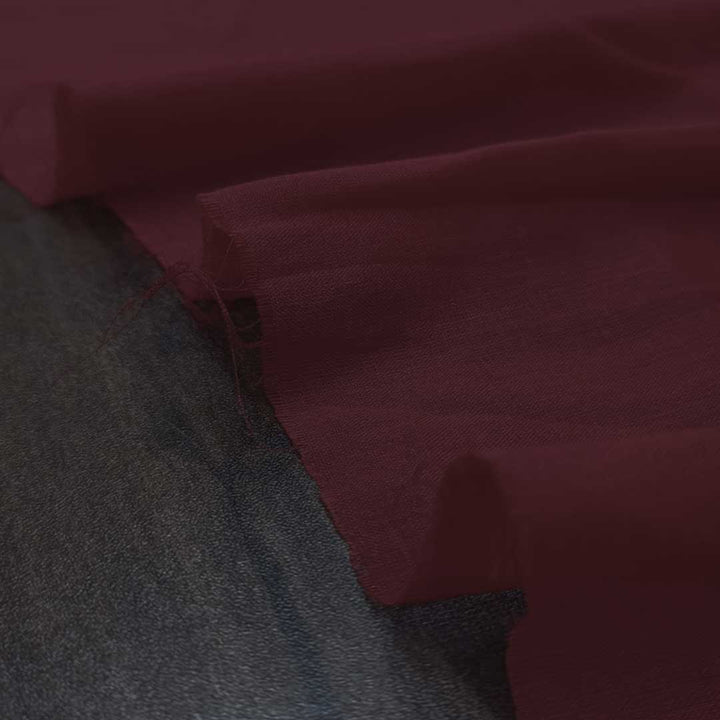 Plush royal maroon mul mul plain cotton fabric, offering unmatched softness and a rich hue for elegant and comfortable garments.
